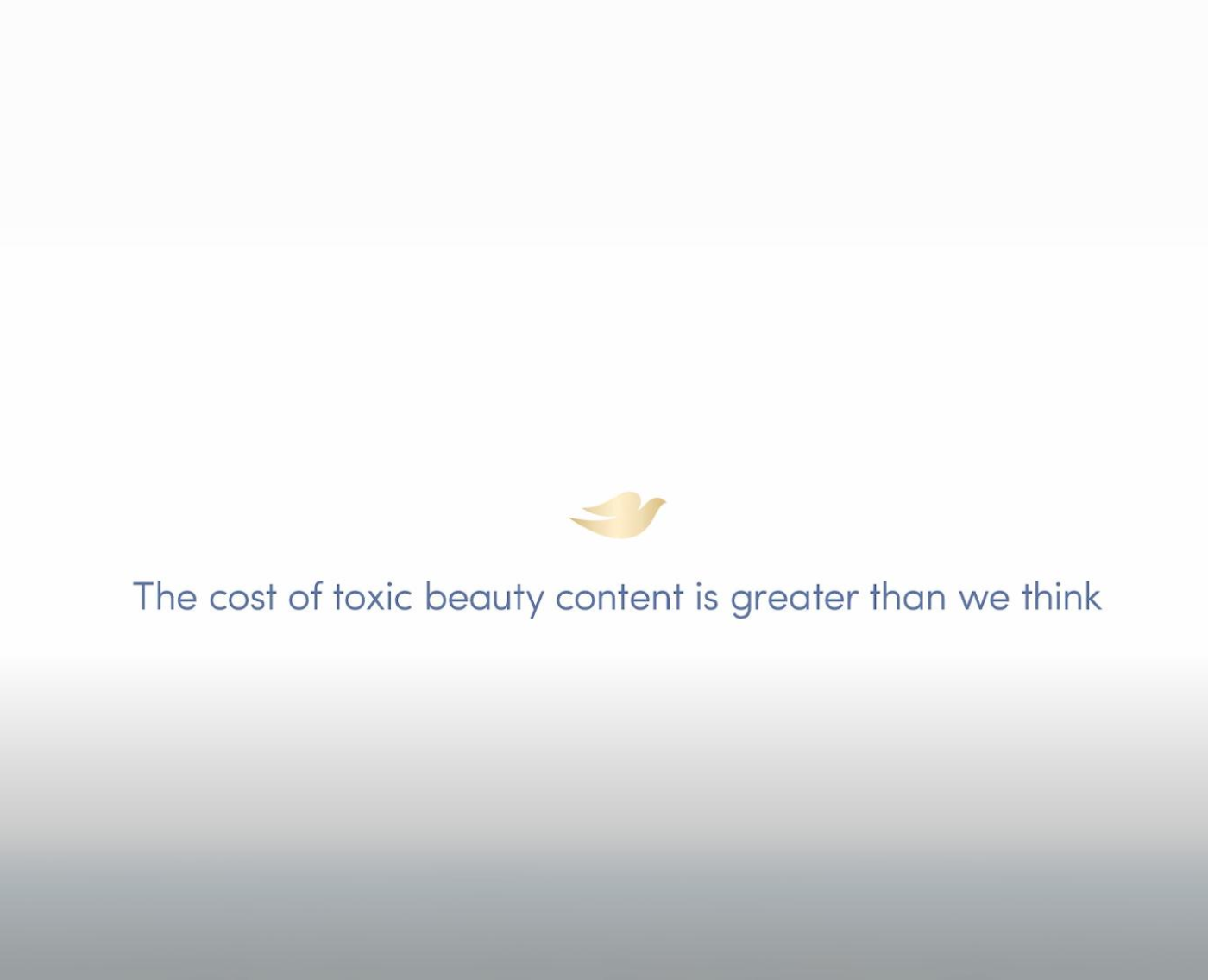 A minimalistic image featuring a white background with a soft gradient towards the bottom. In the centre, there is a small gold dove logo, symbolising the Dove brand. Below the logo, a message is written in blue text: "The cost of toxic beauty content is greater than we think.