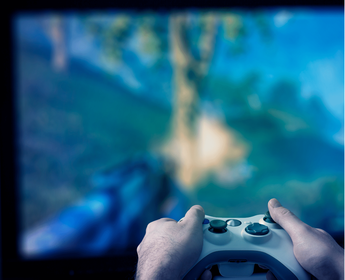 A wider shot showing both hands gripping a white video game controller, focused on a television screen with a blue-green blurred gaming scene in the background.