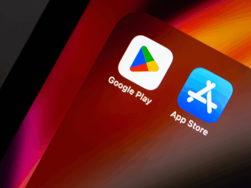 A smartphone screen showing the Google Play and App Store icons side by side on a red-orange gradient background.