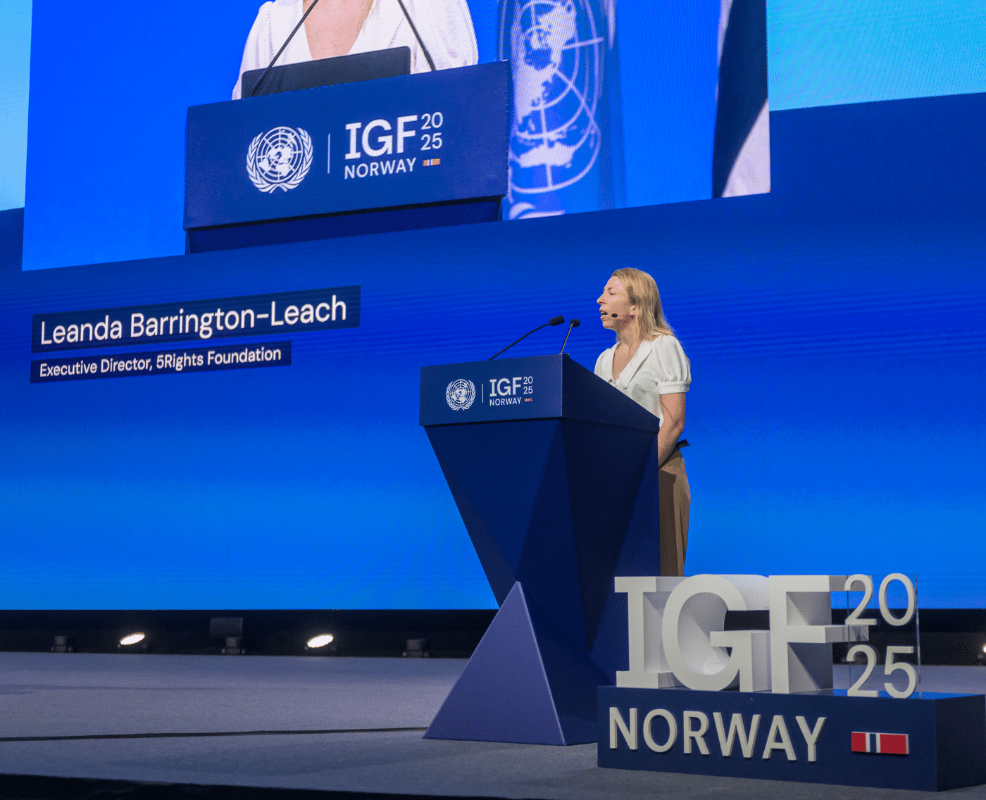 Leanda Barrington-Leach, Executive Director of 5Rights Foundation, delivers the opening remarks at a high-level ministerial panel during the 2025 UN Internet Governance Forum in Norway. She stands at the podium beneath the IGF and UN insignia.