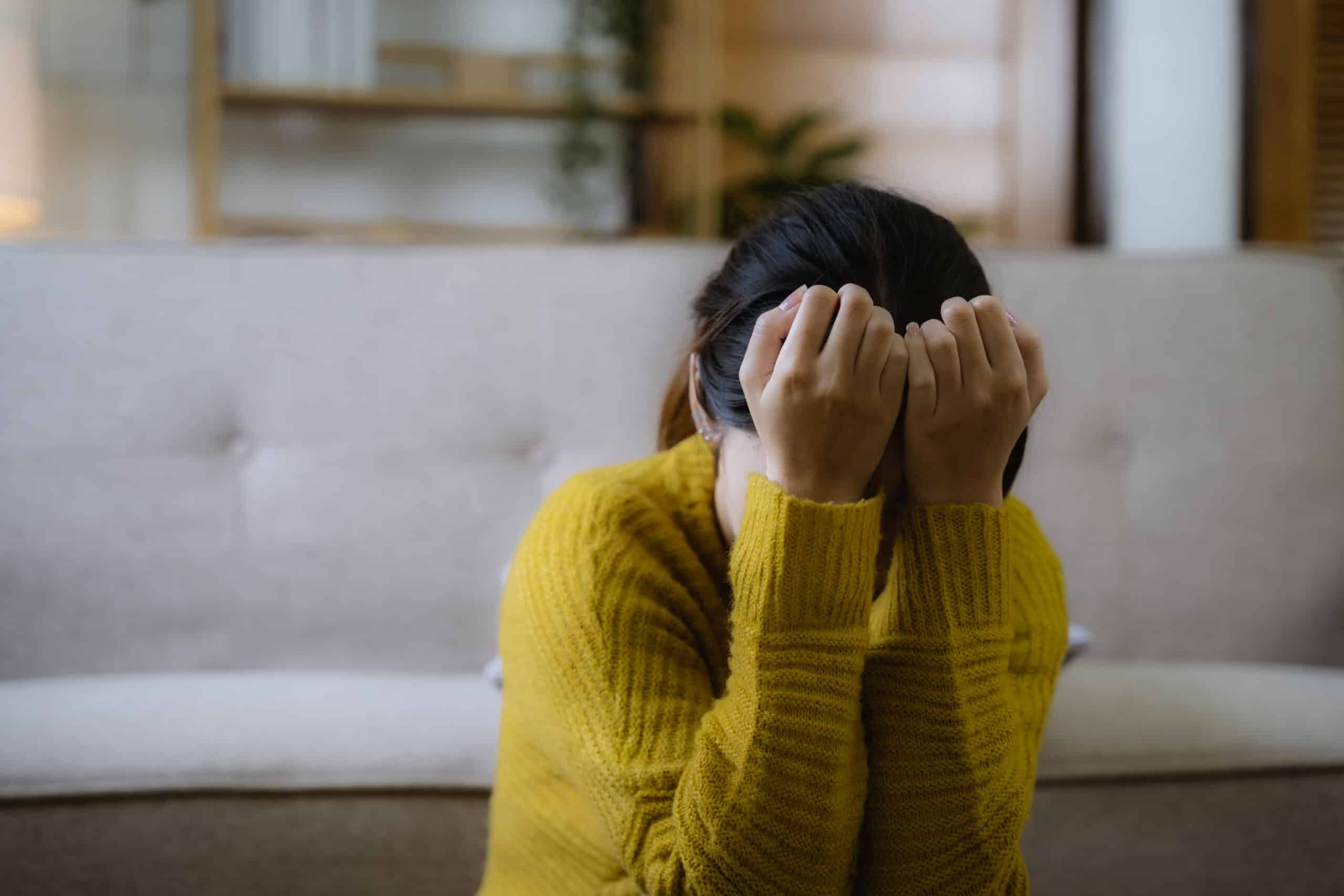 young women with head in hands, upset.