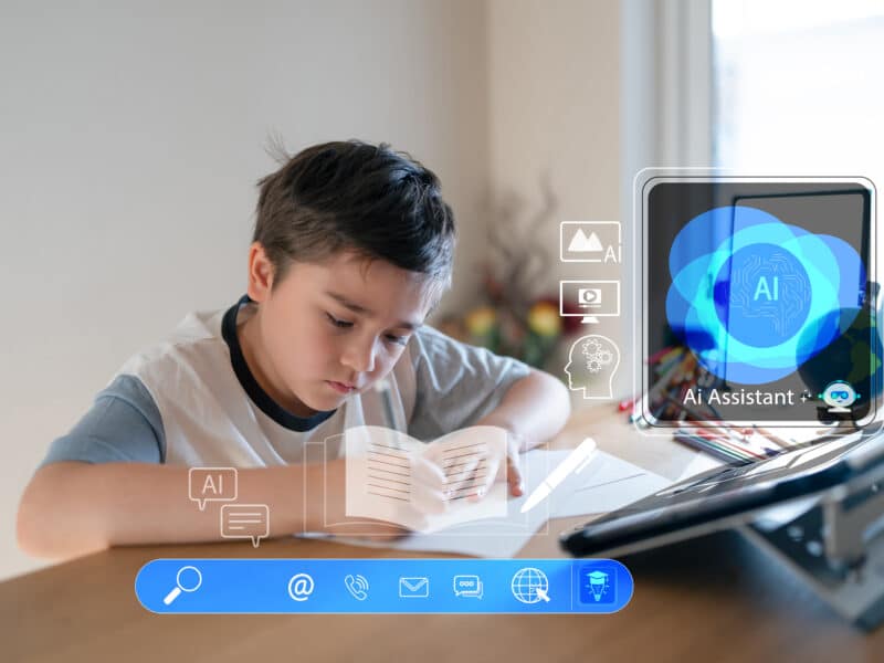 A young child is sitting at their desk doing homework using an AI assistant. The AI assistant is depicted with an overlayed graphic element on the picture.